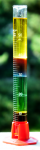 A graduated cylinder containing various coloured liquids with different densities..png